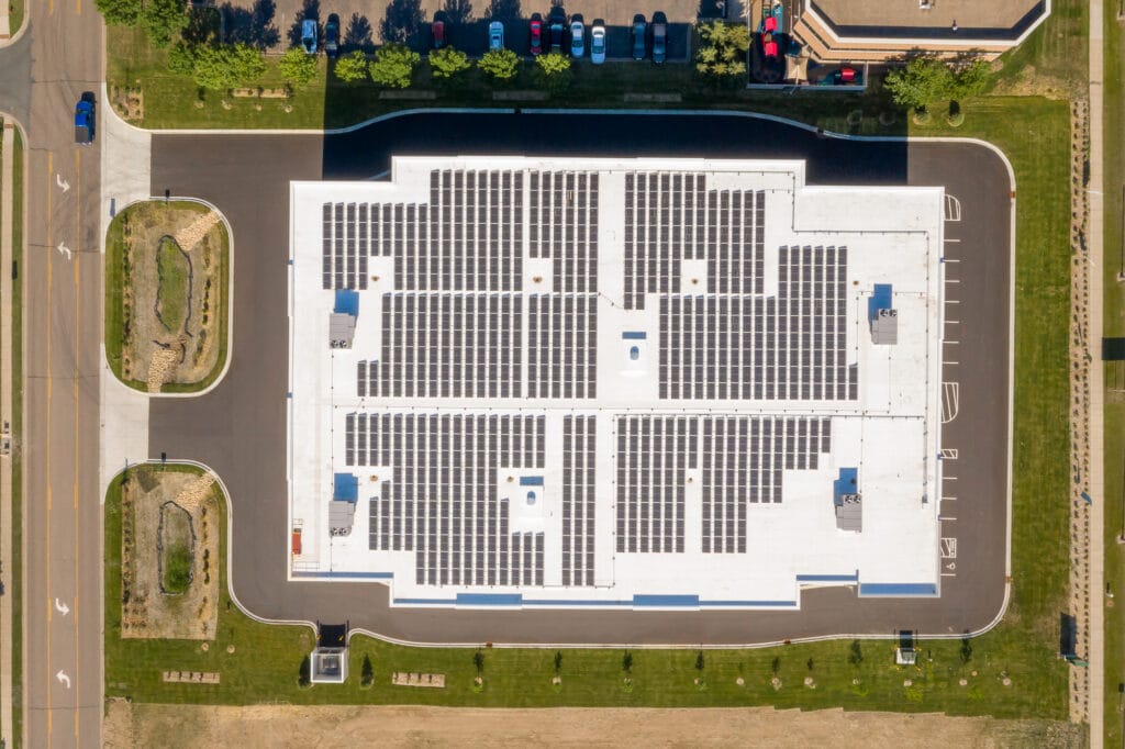 Aerial view looking straight down on solar panels line the roof of a large storage facility in Minnesota. 