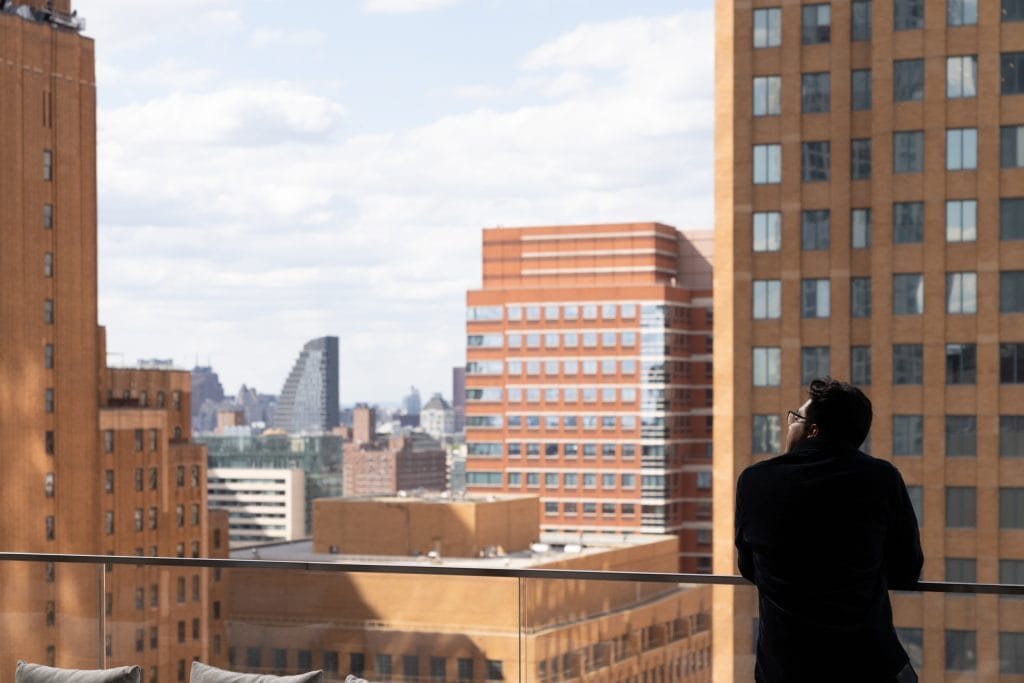 Architectural photographer captures man overlooking downtown Brooklyn from a commercial high rise